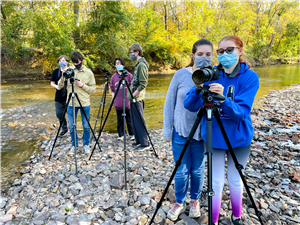 3 cohort groups use camera by the river